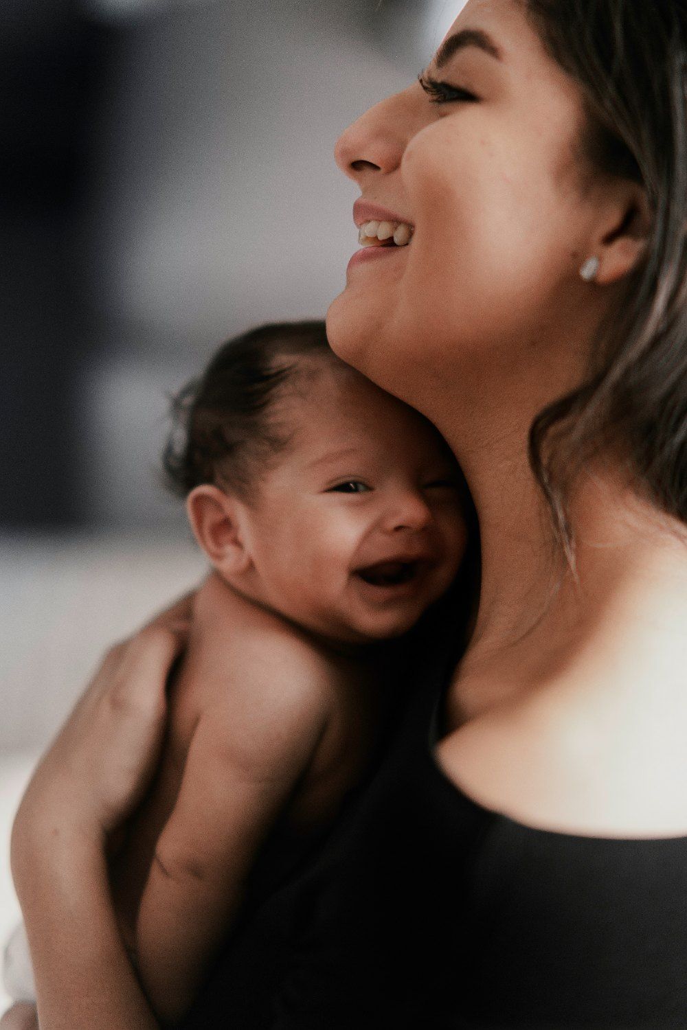 Mãe sorrindo com o bebê no colo